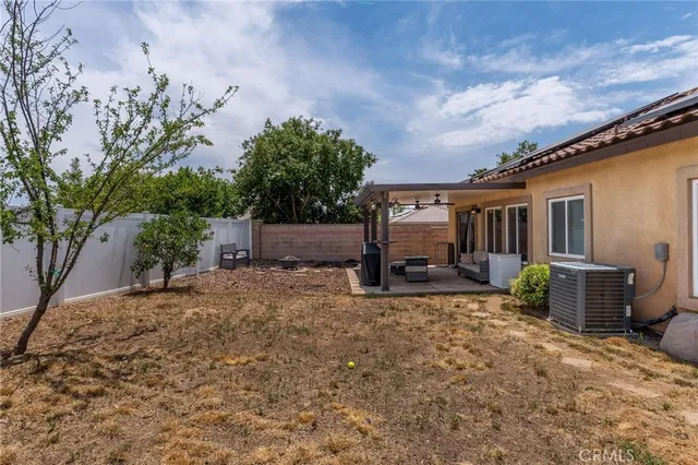 a view of a patio with a table chairs and a backyard