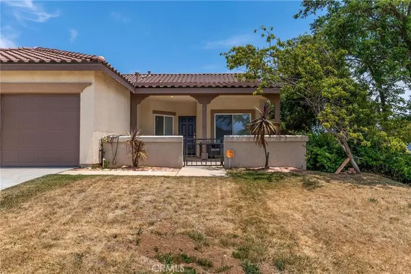 a view of a house with a patio and a yard