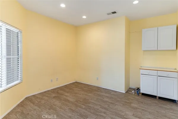 a view of a room with wooden floor and cabinet