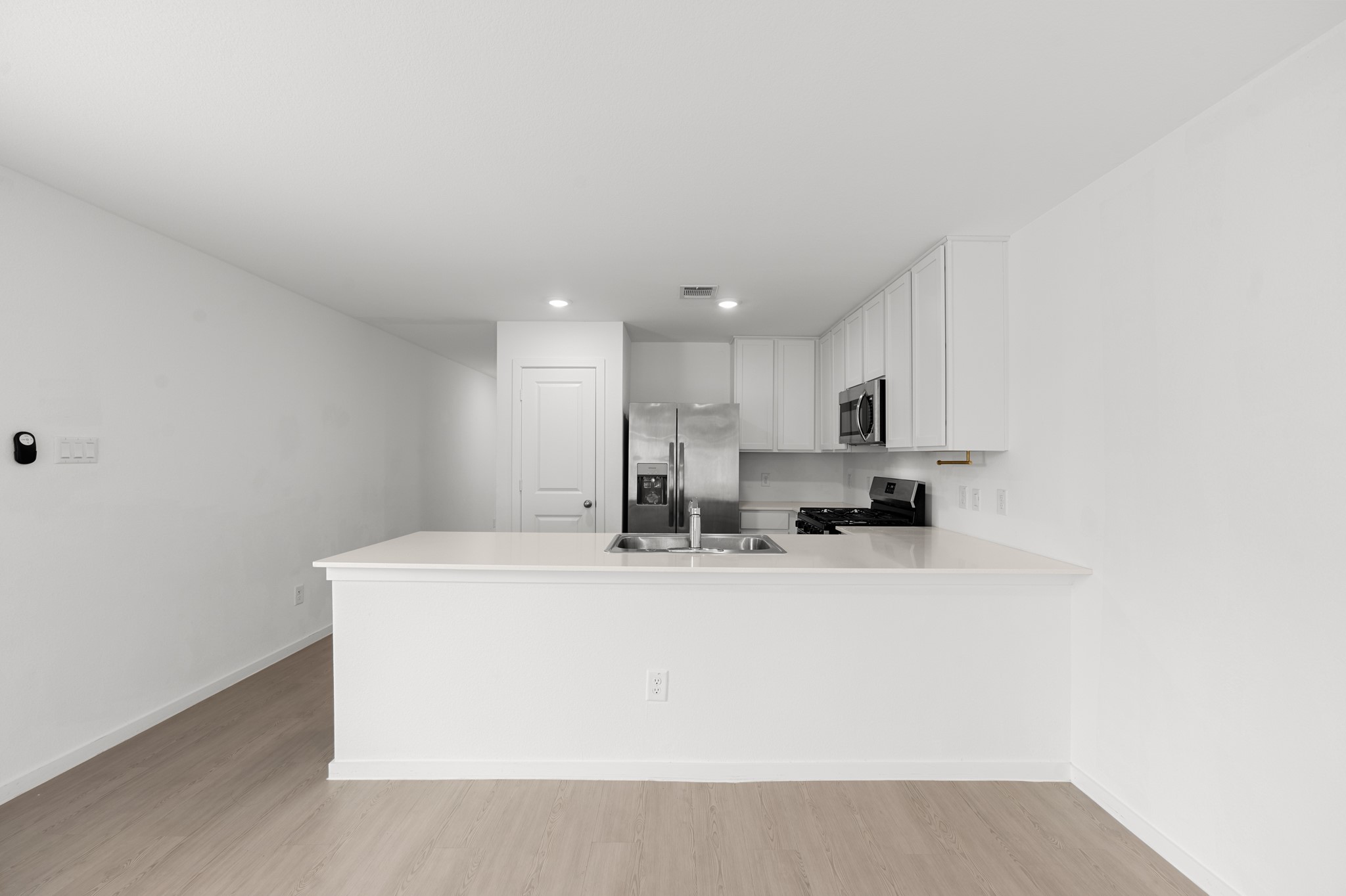 252 Houston Street Angleton, TX 77515 - Photo 5 of 49 Expansive peninsula provides ample prep and serving space while keeping the kitchen visually connected to the surrounding living areas. Crisp white cabinetry pairs with stainless steel appliances for a streamlined finish.