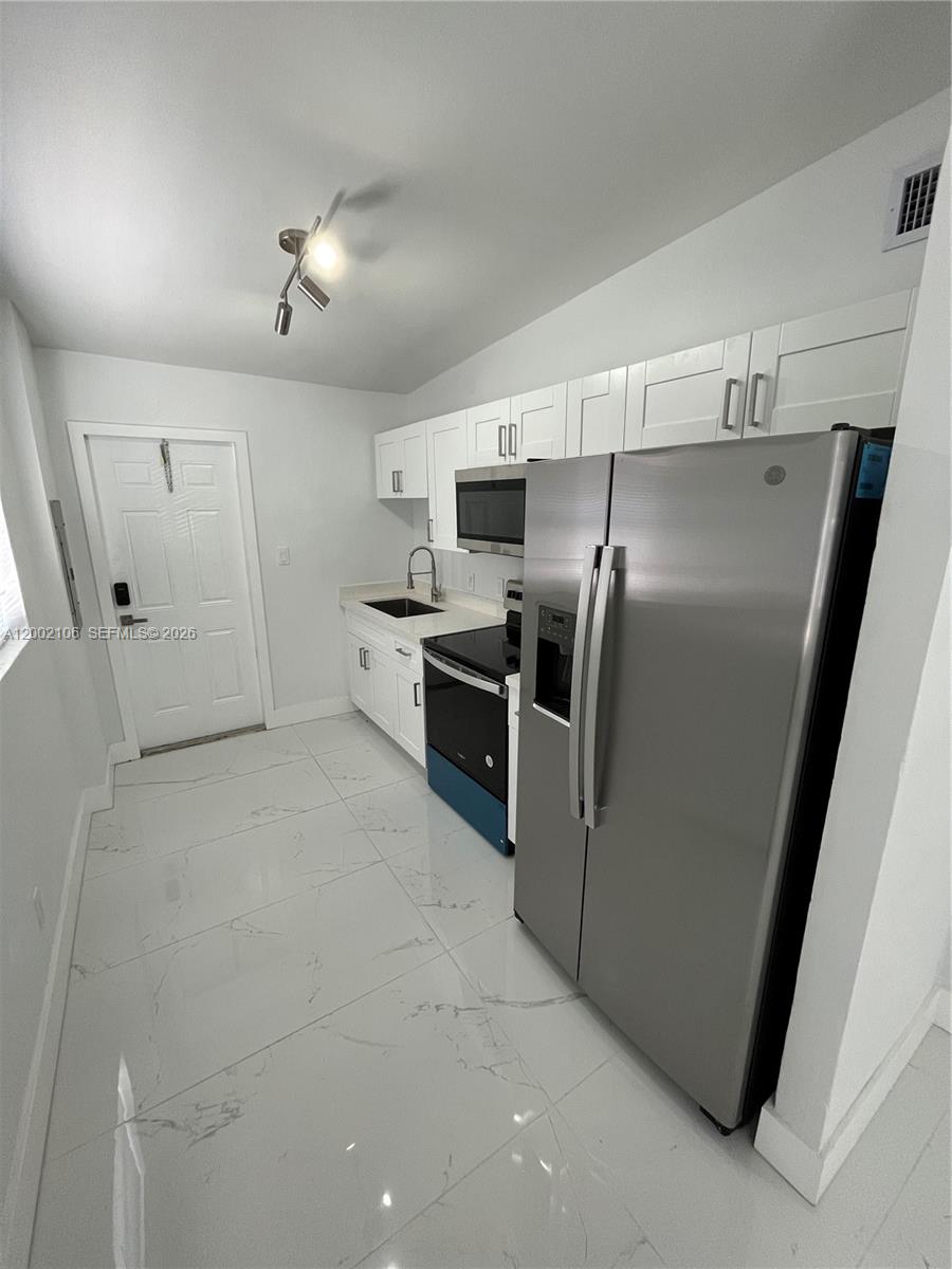 2726 Northwest 4th Court Pompano Beach, FL 33069 - Photo 2 of 11 a kitchen with cabinets and stainless steel appliances