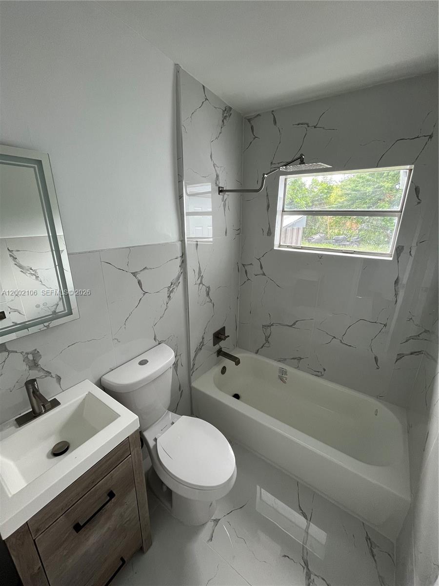 2726 Northwest 4th Court Pompano Beach, FL 33069 - Photo 8 of 11 a bathroom with a bathtub sink mirror vanity and toilet