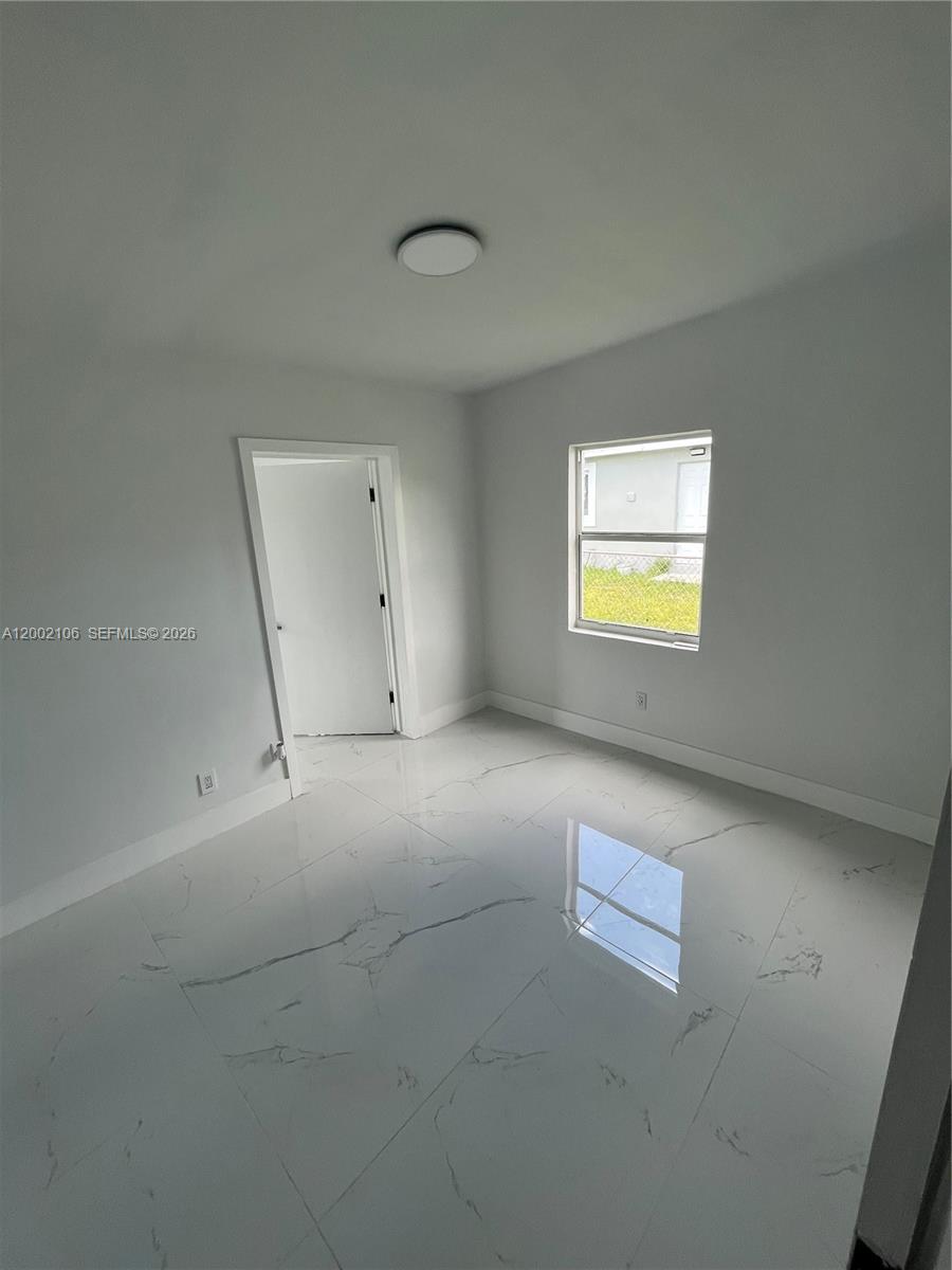 2726 Northwest 4th Court Pompano Beach, FL 33069 - Photo 9 of 11 an empty room with a window