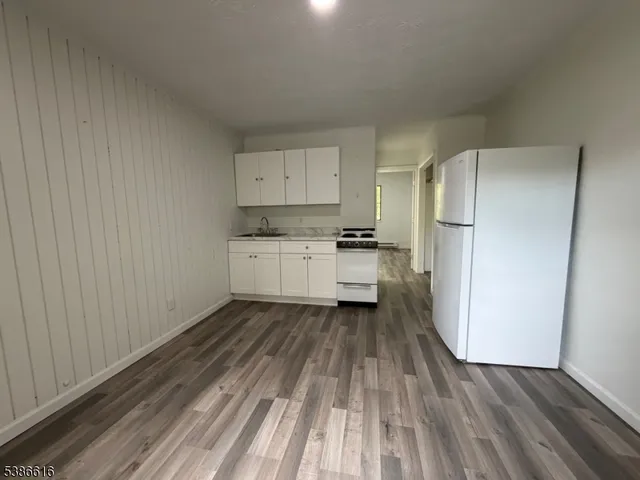 a kitchen with a refrigerator and wooden floor