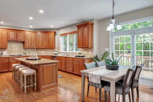 a kitchen with kitchen island granite countertop a sink stove and cabinets