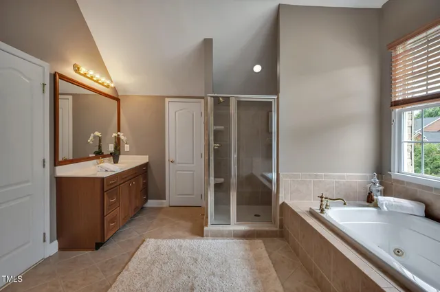a bathroom with a granite countertop toilet a sink a mirror and a shower