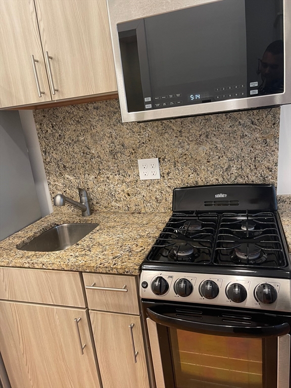 16 5th Street, Unit 8 Chelsea, MA 02150 - Photo 2 of 15 a white stove top oven sitting inside of a kitchen