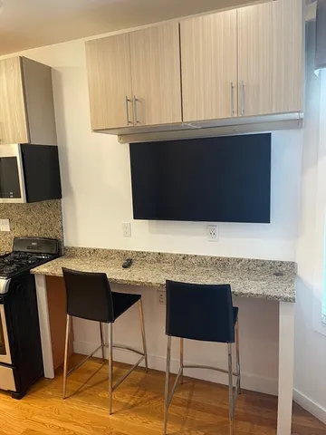 a kitchen with stainless steel appliances kitchen island granite countertop a stove a sink and a microwave