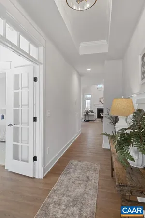 a view of a hallway with wooden floor windows and a chandelier