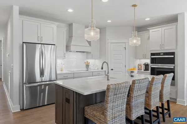a kitchen with stainless steel appliances granite countertop a sink refrigerator and microwave