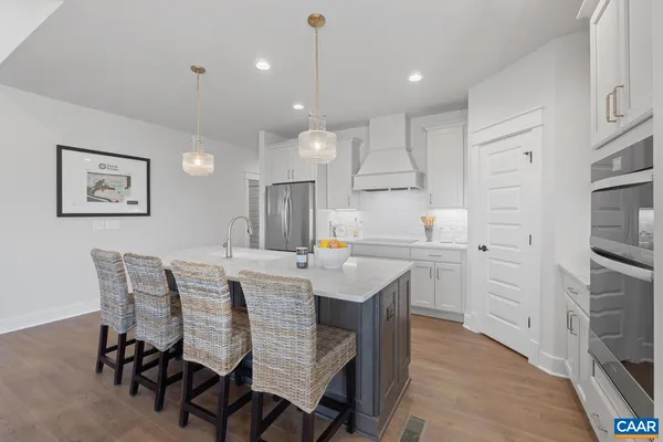 a kitchen with kitchen island white cabinets and stainless steel appliances