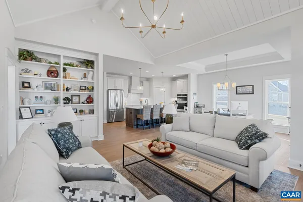 a living room with furniture a rug and a chandelier