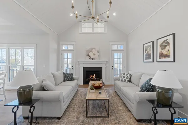 a living room with furniture a chandelier and a fireplace
