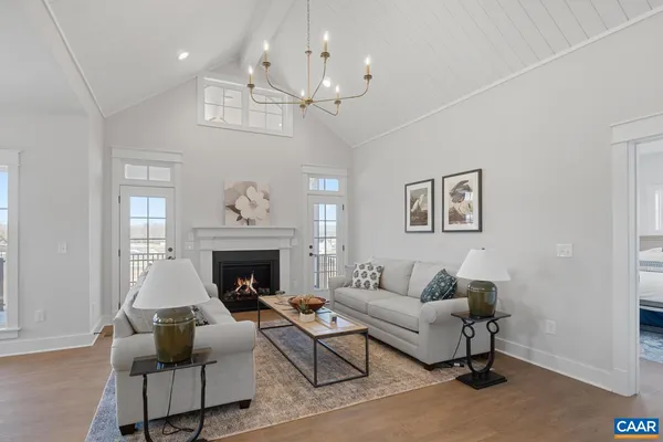 a living room with furniture a chandelier and a fireplace
