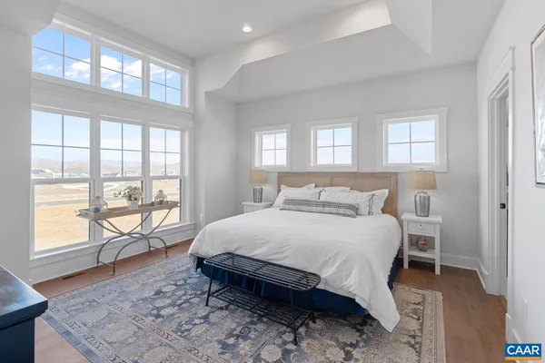a bedroom with a large bed and a large window with outer view