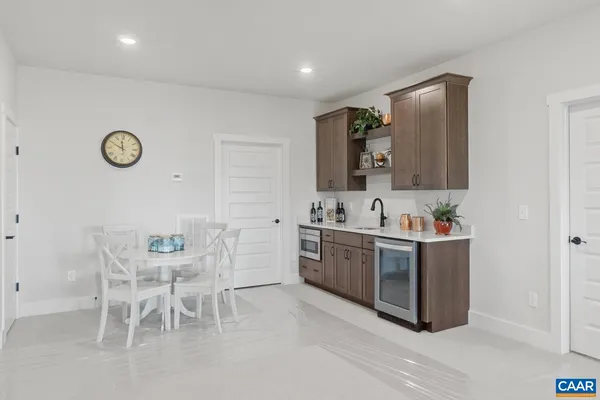 a large white kitchen with cabinets and chairs