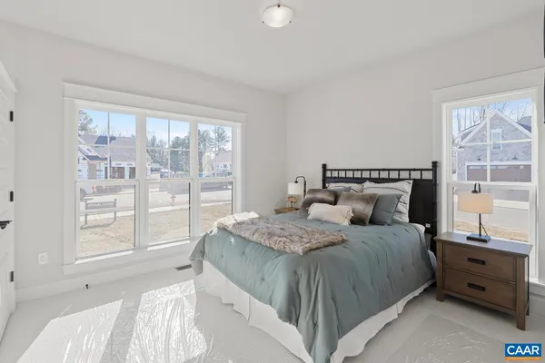 a bedroom with a bed and large windows