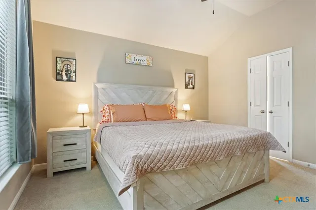 a bedroom with a bed and a flat tv screen on dresser