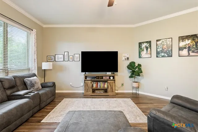 a living room with furniture and a view of kitchen