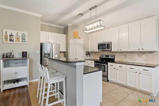 a kitchen with granite countertop a stove top oven microwave and cabinets