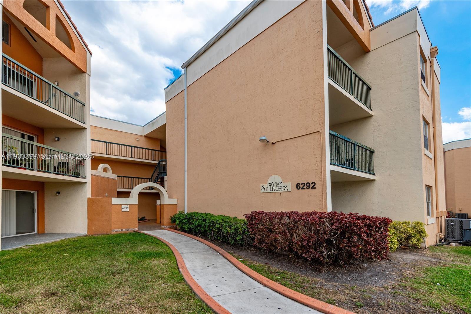 6292 Northwest 186th Street, Unit 214 Hialeah, FL 33015 - Photo 1 of 13 a front view of a house with a yard