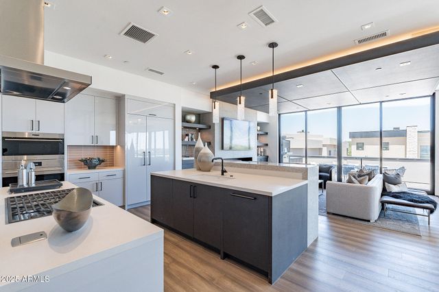a kitchen with stainless steel appliances kitchen island granite countertop a sink and a stove