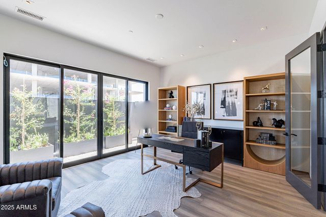 a living room with furniture large window and wooden floor