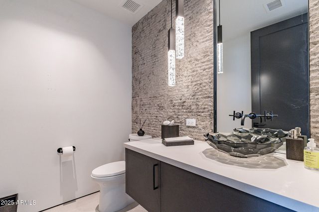 a bathroom with a sink a toilet and mirror