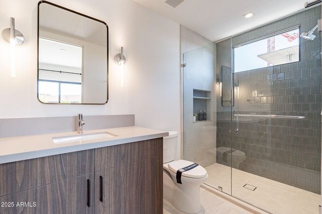 a bathroom with a sink a toilet and shower