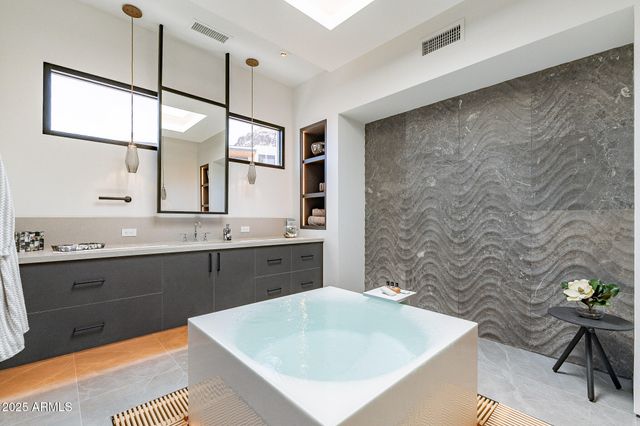 a spacious bathroom with a bathtub sink and mirror
