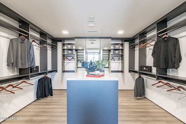 a view of a kitchen with kitchen island a counter top space a sink and wooden floor