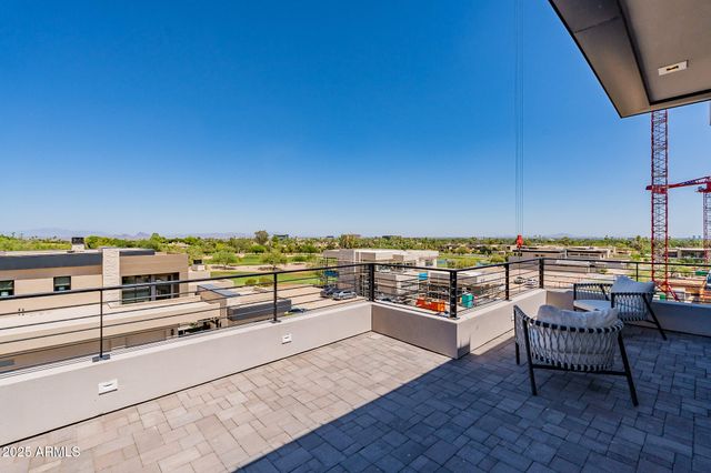 a view of roof deck with seating space and ocean view