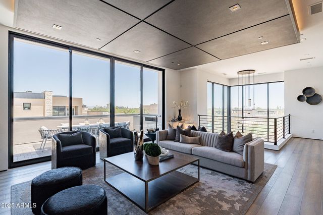 a living room with furniture and floor to ceiling windows