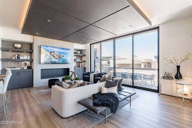a living room with furniture and floor to ceiling windows