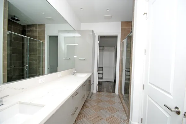 a bathroom with a granite countertop sink a mirror and a shower