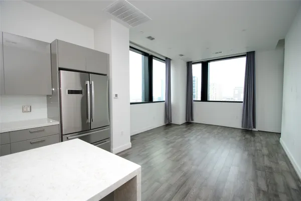 a kitchen with stainless steel appliances kitchen island sink refrigerator and window