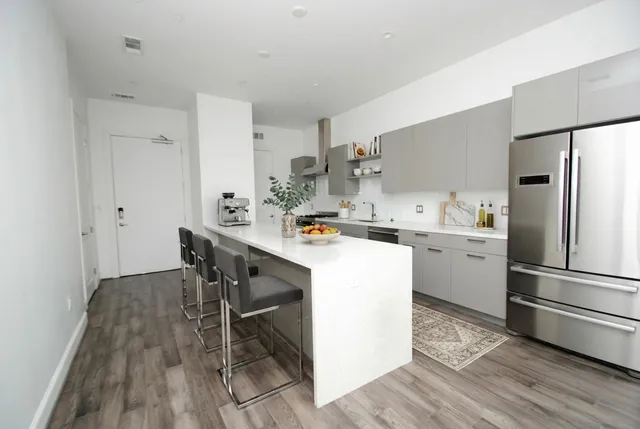 a kitchen with a table chairs refrigerator and cabinets