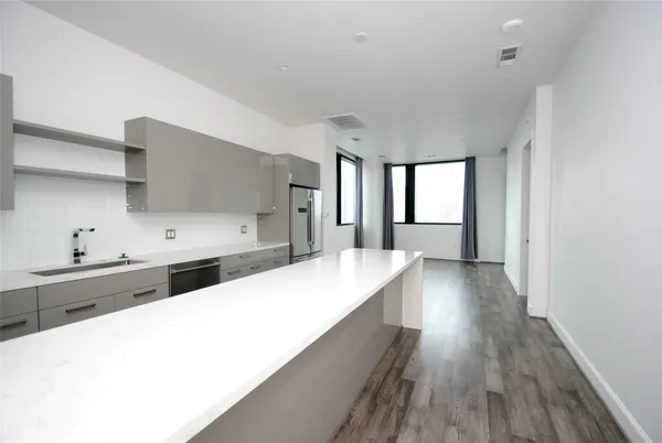 a large kitchen with kitchen island a sink stainless steel appliances and cabinets