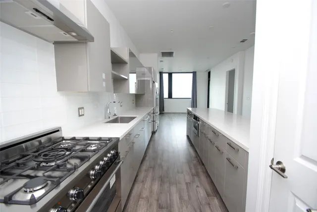 a large kitchen with a stove and wooden floor