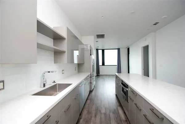 a kitchen with granite countertop a sink and cabinets with wooden floor