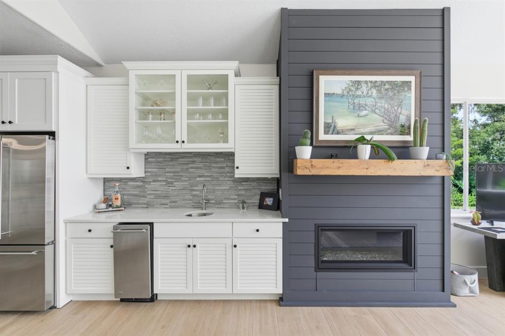 4733 Chuluota Road Orlando, FL 32820 - Photo 9 of 46 a kitchen with stainless steel appliances white cabinets and a fireplace