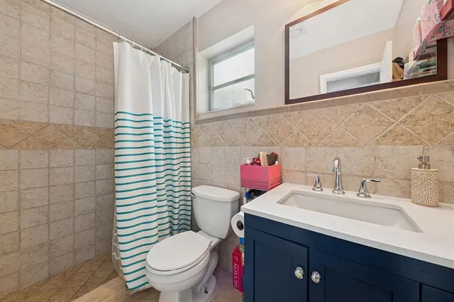 a bathroom with a sink a toilet and shower curtain