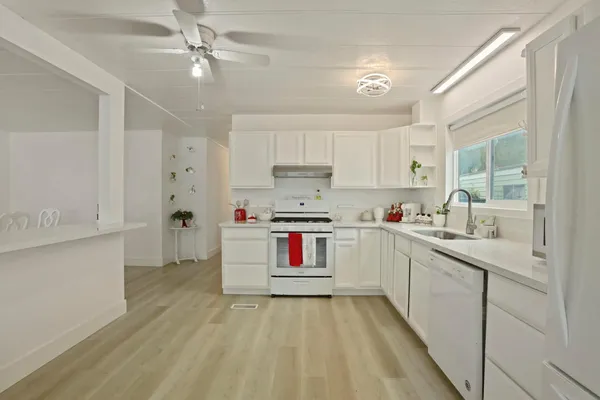 a kitchen with stainless steel appliances granite countertop a sink cabinets and a refrigerator