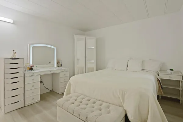 a spacious bedroom with a bed and cabinets