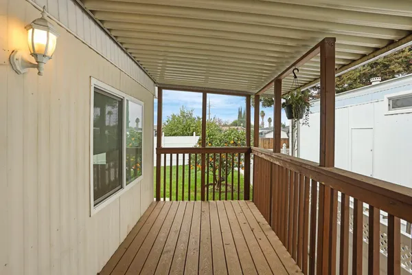 a porch with wooden floor in front of a house