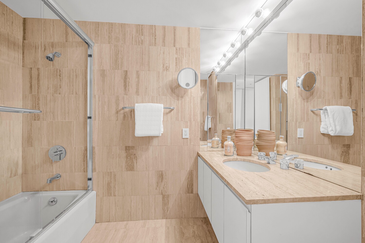 15 West 53rd Street, Unit 46AF Manhattan, NY 10019 - Photo 12 of 17 a bathroom with a sink vanity tub and shower