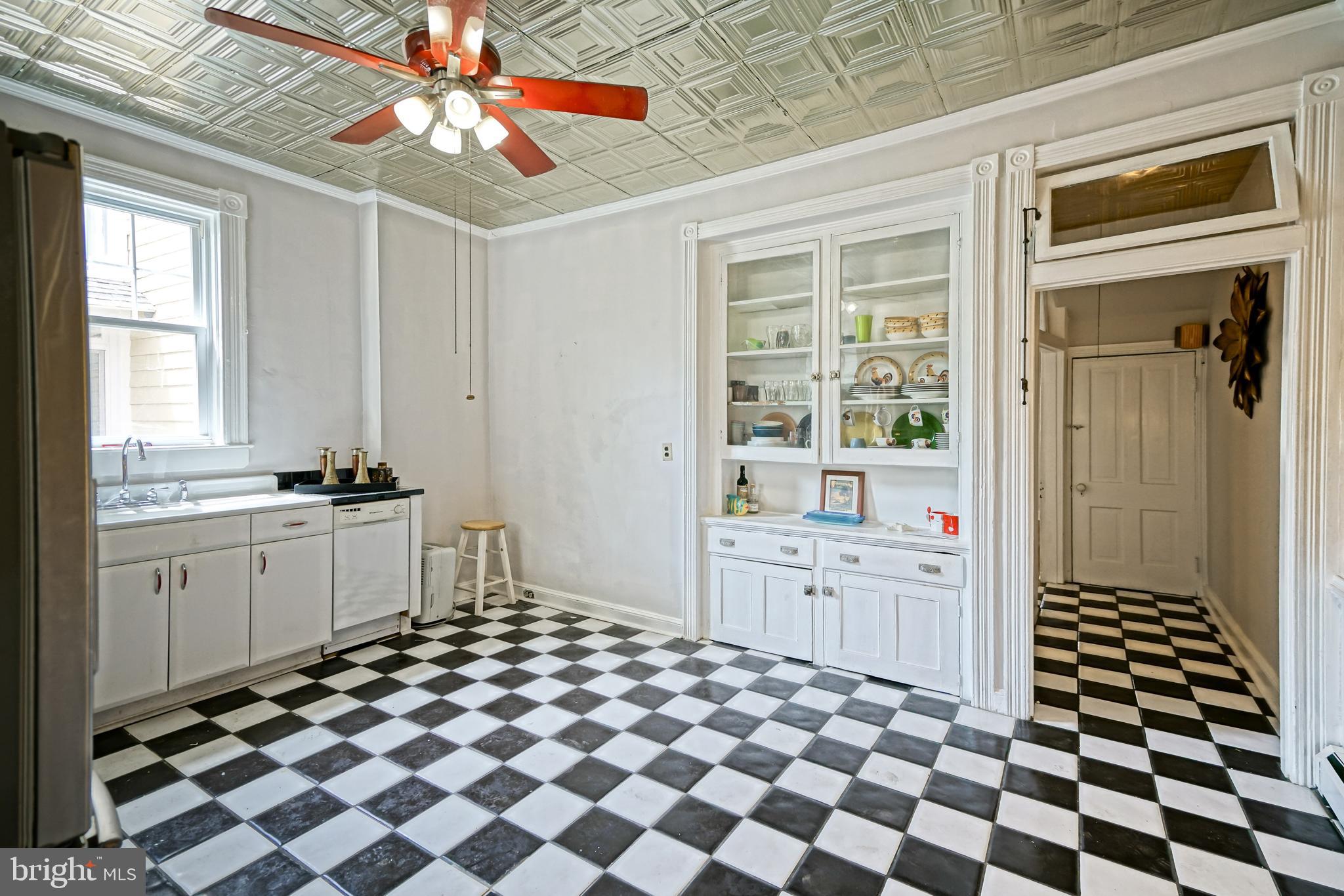 407 Savannah Road Lewes, DE 19958 - Photo 17 of 44 a room with a black white checkered floor with a dining table and chairs