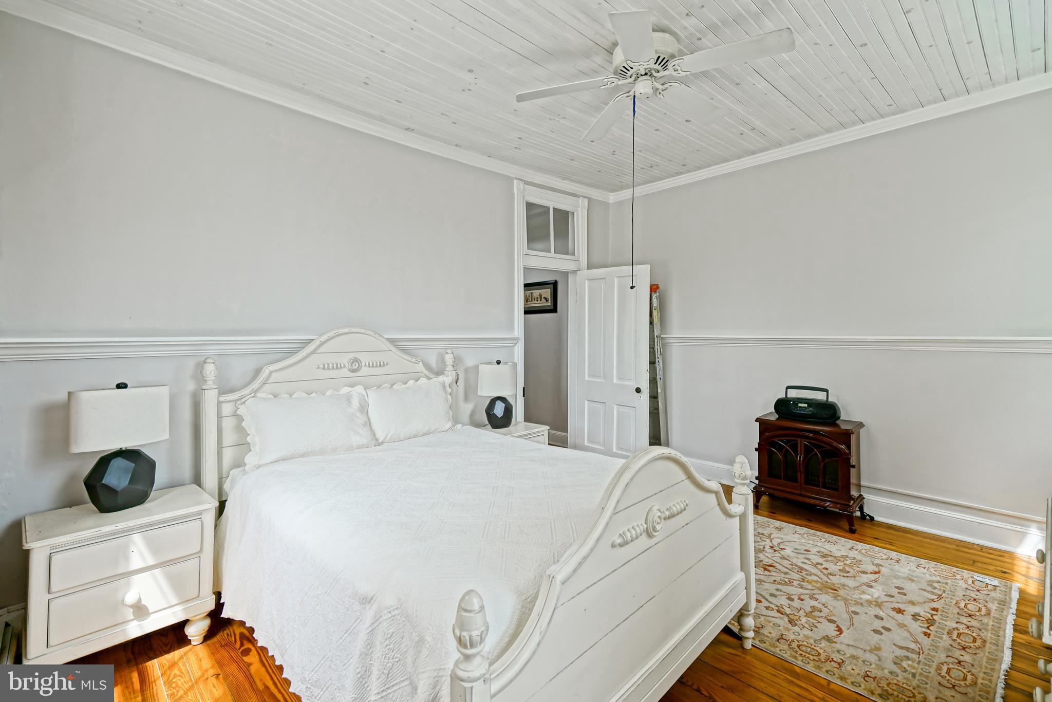 407 Savannah Road Lewes, DE 19958 - Photo 28 of 44 a bedroom with a bed and a chandelier