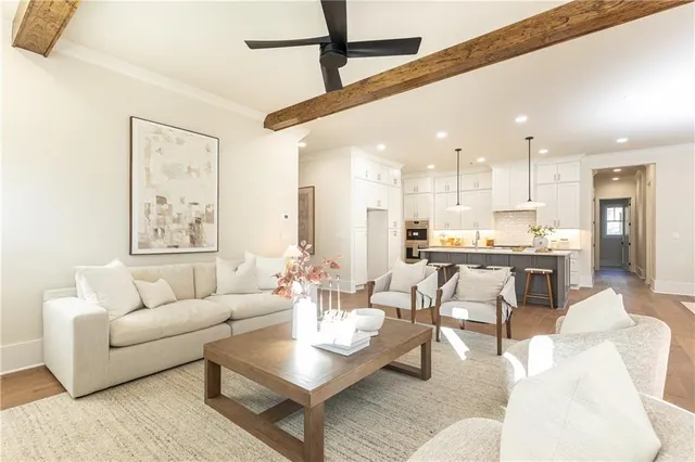 a living room with furniture kitchen view and a large window