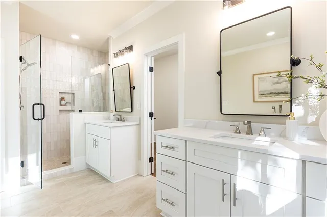a bathroom with a double vanity sink mirror and shower